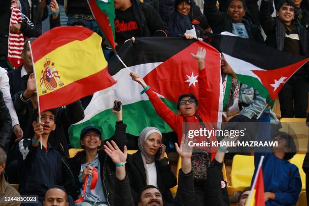 Fans wave Spanish and Jordanian flags ahead of a friendly football match between Jordan and Spain, at the Hussein Youth City stadium, in the...