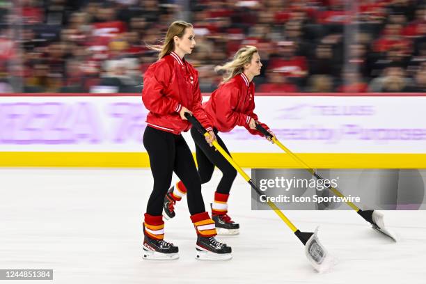 Calgary Flames ice girls clean the ice during the second period of an NHL game between the Calgary Flames and the Winnipeg Jets on November 12 at the...