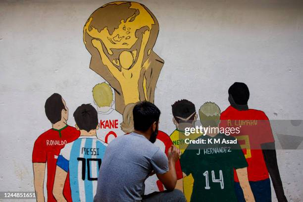 An artist paints a wall with the Fifa world cup trophy to celebrate the upcoming Fifa football world cup which will start on 20 November 2022 in...