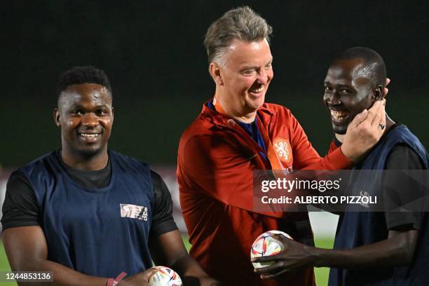 Netherlands' coach Louis van Gaal poses with a player from a football team of the delegation of workers during a training session at Qatar University...