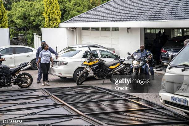 South African Police Service officers prepare to load seized motorcycles on a truck at a house in Bryanston, Johannesburg, on November 17, 2022...