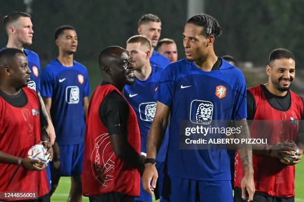 Netherlands' defender Virgil van Dijk poses for pictures with a football team of the delegation of workers during a training session at Qatar...