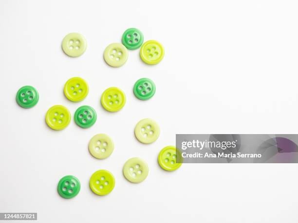 green buttons against white background - button craft stock pictures, royalty-free photos & images