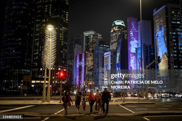 People cross a street in Doha on November 17 ahead of the Qatar 2022 World Cup football tournament.