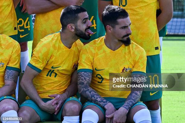 Australia's Aziz Behich gestures to his teammate Jamie MacLaren as they pose for the official team group photograph at the Aspire Academy in Doha on...