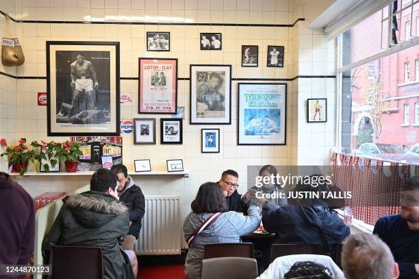 People have a traditional English breakfast at Regency Cafe in London on November 17, 2022. - A "full English breakfast" is not full without eggs....