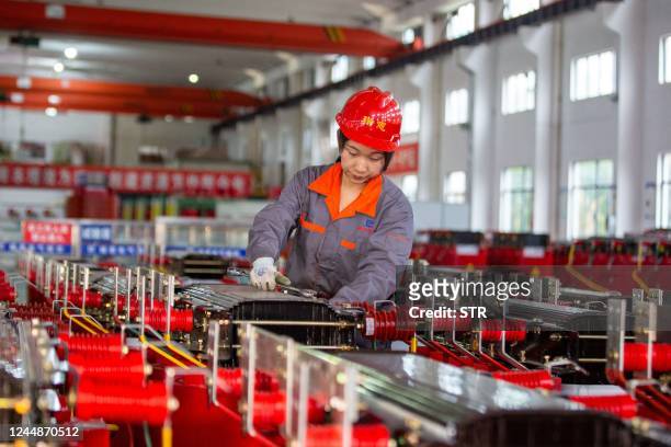 This photo taken on November 17, 2022 shows a worker manufacturing transformers at a factory in Haian in China's eastern Jiangsu province. - China...