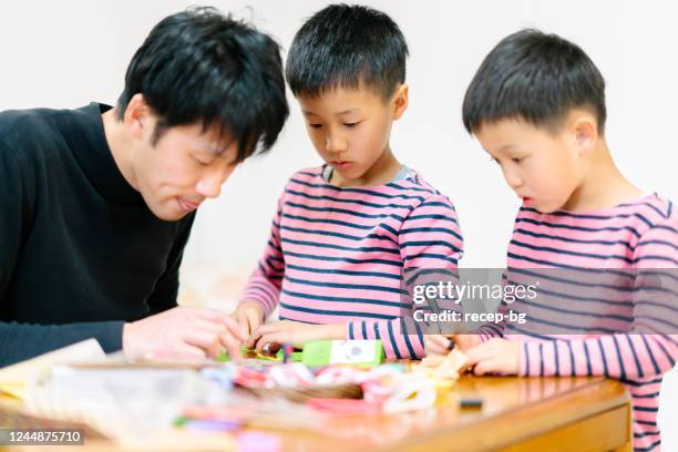 family spending time together making craft together at home. - origami asia stock pictures, royalty-free photos & images