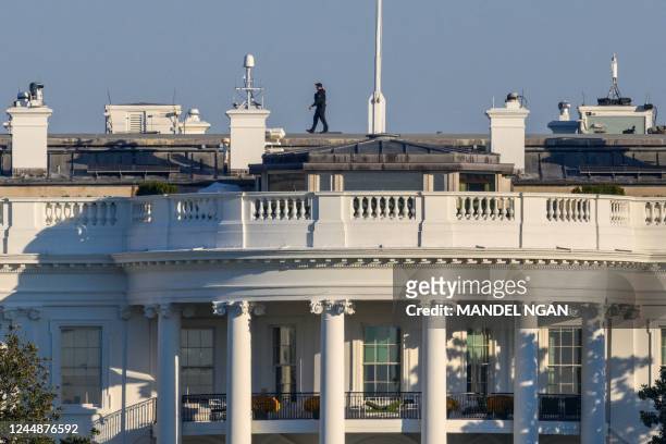 Member of the Secret Service Uniformed Division walks above the South Portico and South Lawn of the White House in Washington, DC on November 18,...