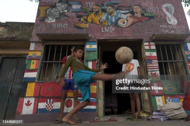 Children play next to murals of global footballers at Chetla ahead of Qatar Football World Cup 2022 on November 18, 2022 in Kolkata, India.