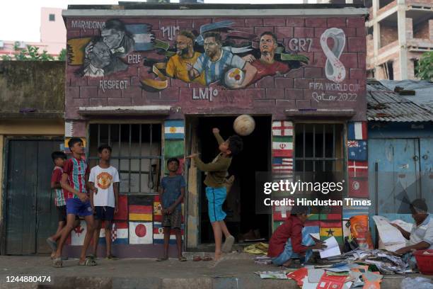 Children play next to murals of global footballers at Chetla ahead of Qatar Football World Cup 2022 on November 18, 2022 in Kolkata, India.