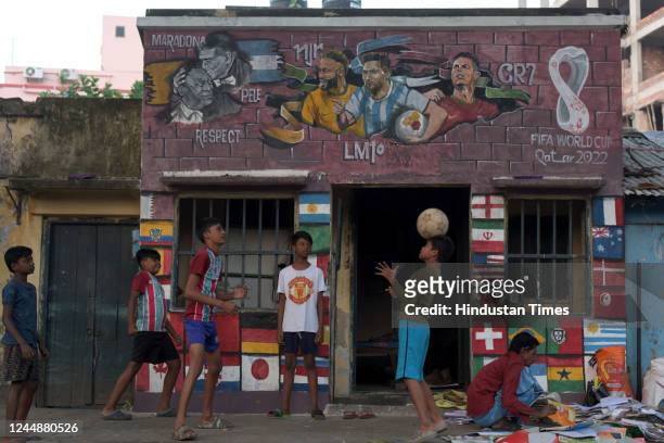 Children play next to murals of global footballers at Chetla ahead of Qatar Football World Cup 2022 on November 18, 2022 in Kolkata, India.