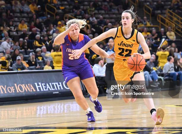 Iowa guard Caitlin Clark drives to the basket as Evansville guard Lexie Sinclair defends during a women's college basketball game between the...