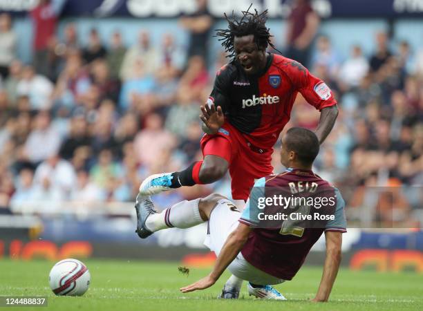 Benjani of Portsmouth is challenged by Winston Reid of West Ham United during the npower Championship match between West Ham United and Portsmouth at...