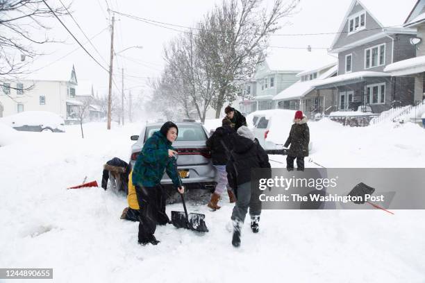 Brenna Grigsby, Braylee Zimmer, Jaden Ardy, Nadia Velez, Patty Velez, Jason Ardy and Lizette Torres work to free a car stuck in the snow after a...