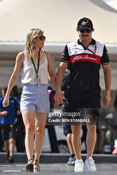 Alfa Romeo's Finnish driver Valtteri Bottas arrives to the track with his girlfriend, pro cyclist Tiffany Cromwell, before the third practice session...