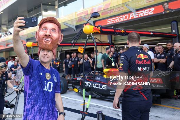 Fan wearing an Argentinian football legend Lionel Messi costume takes a selfie in the pits before the third practice session ahead of the Abu Dhabi...