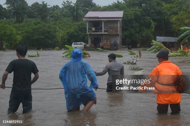 Members of the Joint Mobile Brigade Unit Battalion B, National Search and Rescue Agency, TNI, and BPB search for residents trapped in floods in...