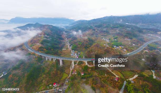 Highway passes through a village in Anqing City, Anhui Province, China, Nov 19, 2022. The wide cement road leads into the village, and the mountains,...