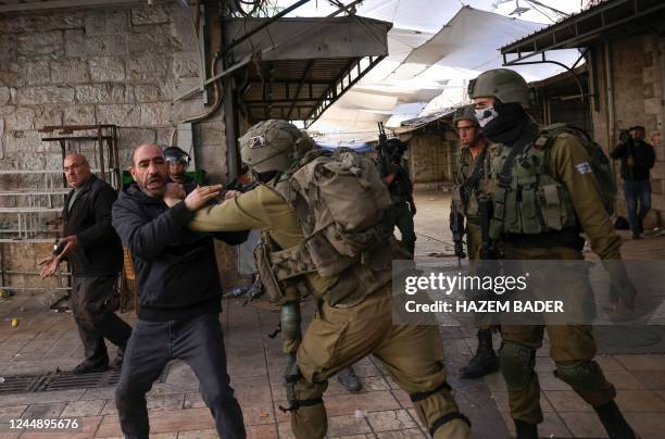 Israeli security forces hold back a Palestinian man, amid altercations between Jewish settlers on their way to visit the tomb of Othniel ben Kenaz in...