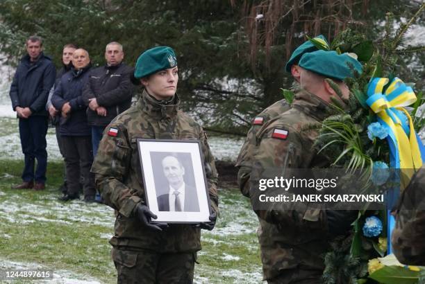 Polish soldier carries a picture of one of two victims of a missile that hit a southeastern Polish village near the border with Ukraine, during his...