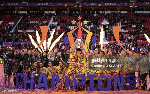 Australia's players pose with the winner's trophy during the presentation ceremony after the Rugby League World Cup Women's final between Australia...