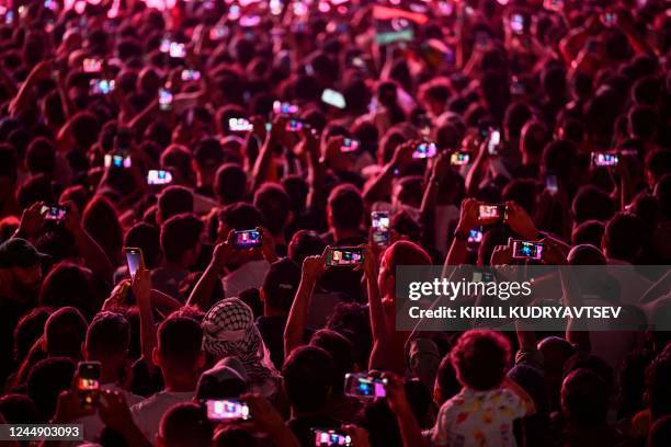 Supporters film with their smartphones as they attend the FIFA Fan Festival opening day at Al Bidda park in Doha on November 19 ahead of the Qatar...