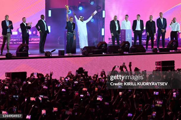 Brazilian former football player Cafu holds the trophy as he takes part of an event along with former football players Marcel Desailly of France, ,...