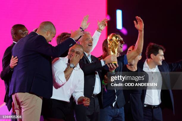 Former World Cup winners including Alessandro Altobelli of Italy and Roberto Carlos of Brazil pose with the trophy on stage during the FIFA Fan...