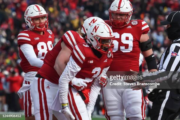 Wide receiver Trey Palmer of the Nebraska Cornhuskers celebrates scoring with tight end Travis Vokolek and offensive lineman Turner Corcoran and wide...