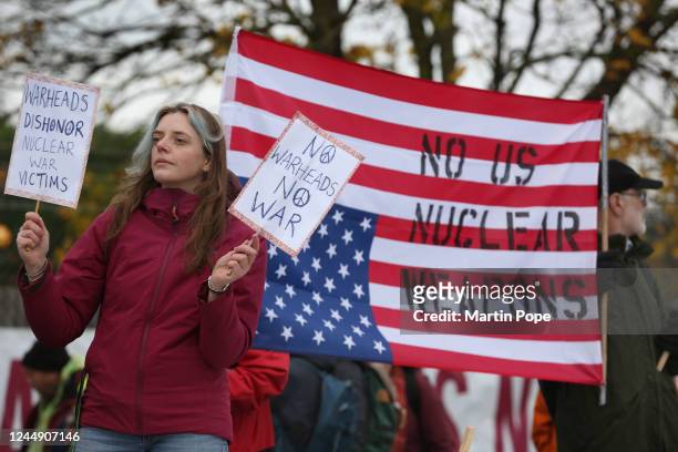 Protester holds anti -nuclear weapon signs in front of an upside down United States flag written with the slogan'No US Nuclear Weapons' on November...