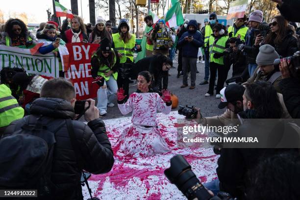 Naz Gharai, from Tehran, is covered in red paint as protesters call on the United Nations to take action against the treatment of women in Iran,...