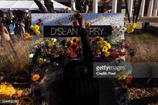 Person places a flower on a memorial for D'Sean Perry before a memorial service for three slain University of Virginia football players Lavel Davis...