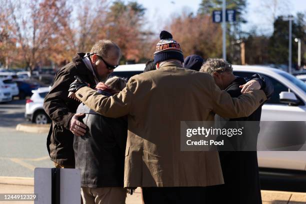 People embrace before a memorial service for three slain University of Virginia football players Lavel Davis Jr., D'Sean Perry and Devin Chandler at...