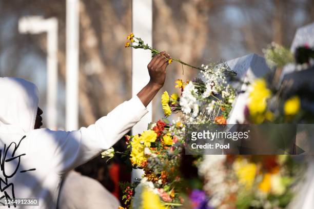 Person places a flower on a memorial before a memorial service for three slain University of Virginia football players Lavel Davis Jr., D'Sean Perry...