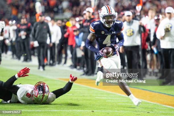 Cornerback D.J. James of the Auburn Tigers runs the ball by tight end Joshua Simon of the Western Kentucky Hilltoppers during the second half of play...
