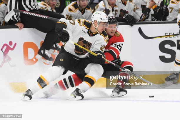 Hampus Lindholm of the Boston Bruins skates against Philipp Kurashev of the Chicago Blackhawks at the TD Garden on November 19, 2022 in Boston,...