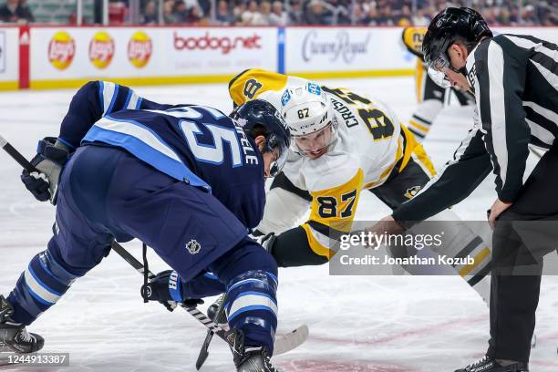 Mark Scheifele of the Winnipeg Jets and Sidney Crosby of the Pittsburgh Penguins take a first period face-off at the Canada Life Centre on November...