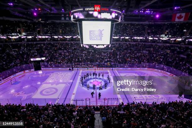 General view of the arena bowl as members of the Winnipeg Jets and the Pittsburgh Penguins raise their sticks at centre ice while fans light up the...