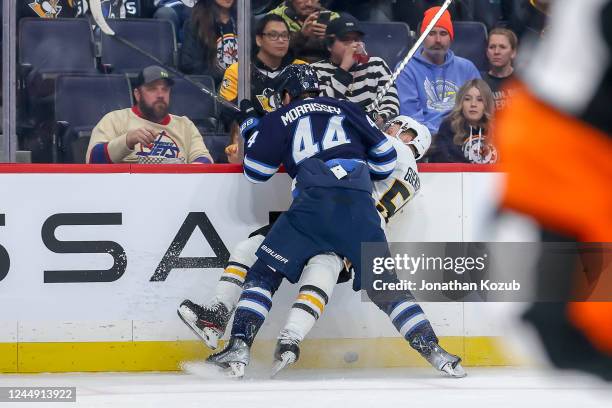 Josh Morrissey of the Winnipeg Jets checks Jake Guentzel of the Pittsburgh Penguins into the boards during first period action at the Canada Life...