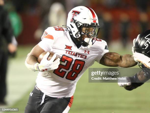 Running back Tahj Brooks of the Texas Tech Red Raiders runs up the field during the second half in front of defensive back Treyveon McGee of the Iowa...