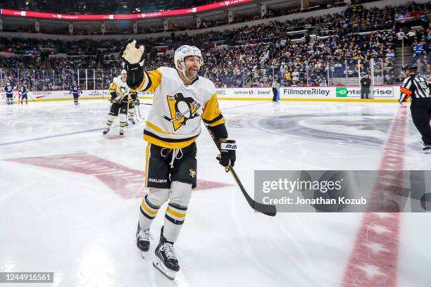 Jason Zucker of the Pittsburgh Penguins skates towards the bench to celebrate his third period goal against the Winnipeg Jets with teammates at the...