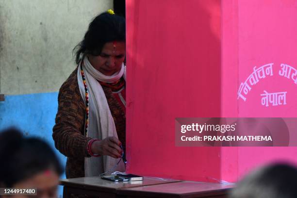 Voter prepares to stamp her ballot to vote in the general election at a polling station in Bhaktapur on the outskirts of Kathmandu on November 20,...