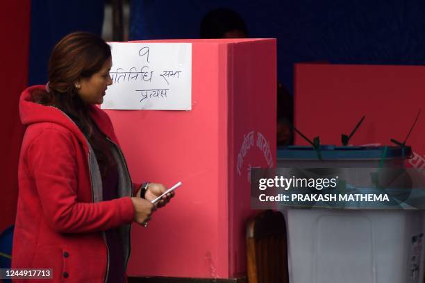 Voter prepares to drop her ballot for the general election at a polling station in Bhaktapur on the outskirts of Kathmandu on November 20, 2022. -...