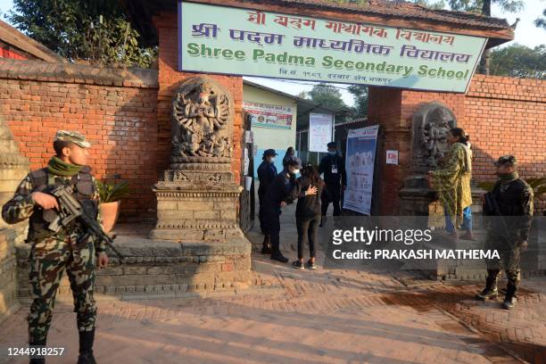Voter is checked by a police officer before voting during the general election in Bhaktapur on the outskirts of Kathmandu on November 20, 2022. -...