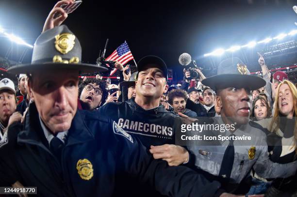 South Carolina state troopers help escort South Carolina Gamecocks coach Shane Beamer off the field after fans rush the field following a college...