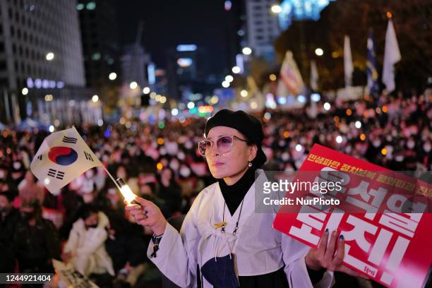 People hold placards and shout slogans during the 15th candlelight vigil around Seoul City Hall demand the resignation of President Yoon Suk-yeol and...
