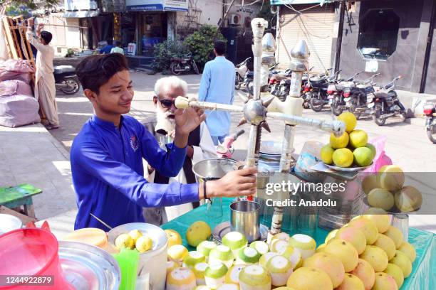 Pakistani young vendor prepares juices to sell to customers to help in the living of his poverty stricken family on the eve World Children Day in...