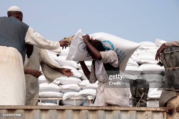 Sacs of corn are loaded onto trucks in the Sudanese Red Sea city of Port Sudan, as part of the US support for Sudan in the field of humanitarian aid,...