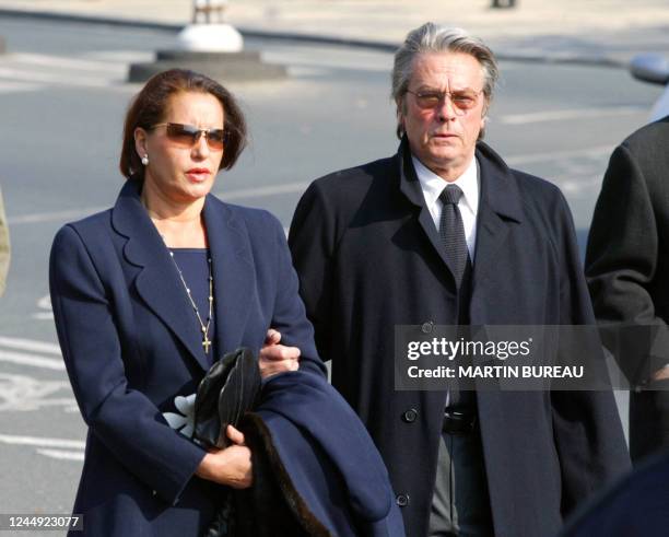 L'acteur Alain Delon et une personne non identifiée sortent de l'église Saint François-Xavier, le 20 mars 2003 à Paris, lors des obsèques de Jean-Luc...